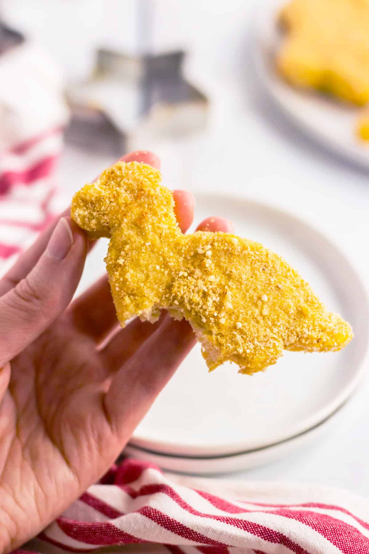 dinosaur shaped homemade chicken nugget with a bite taken out