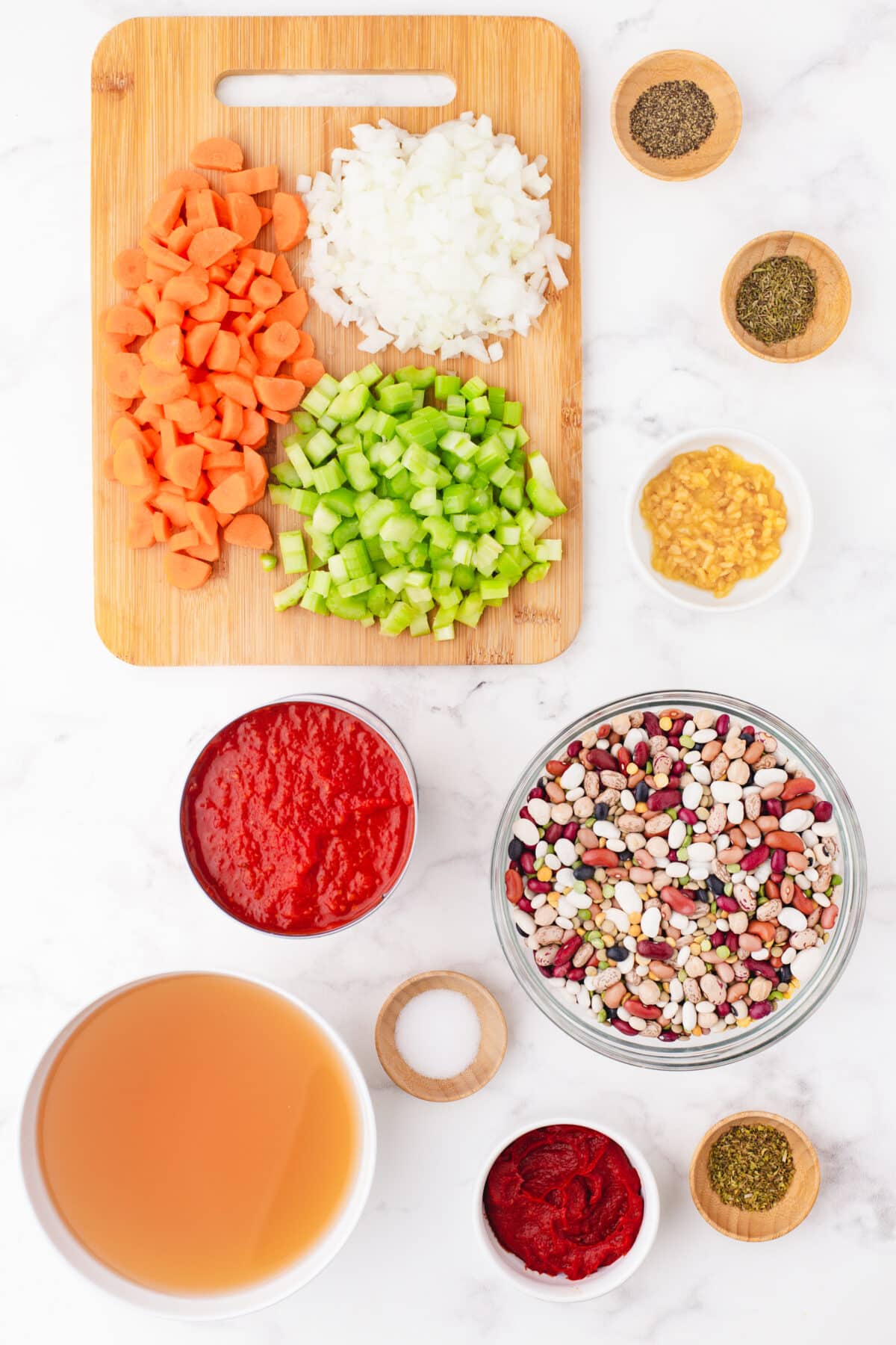 Ingredients for 15 bean soup on a cutting board and small wooden pinch bowls