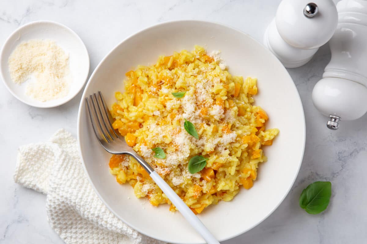 butternut squash risotto in a white bowl on a marble countertop