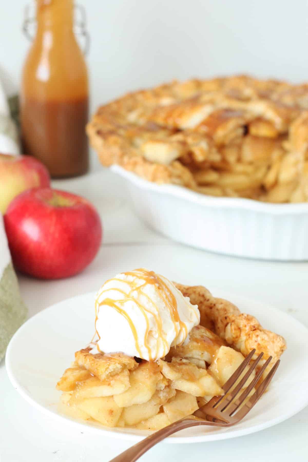 slice of caramel apple pie topped with vanilla ice cream