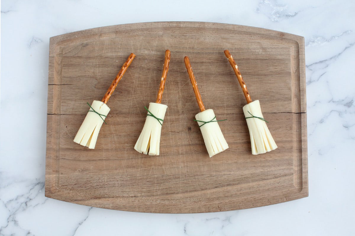 string cheese witches brooms on a cutting board