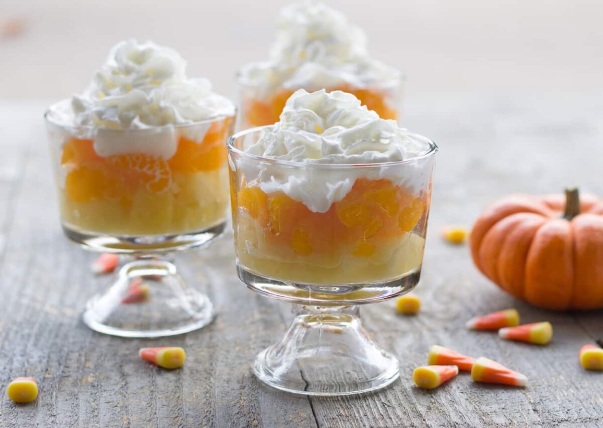 glass parfait cups layered with pineapple oranges, and whipped cream