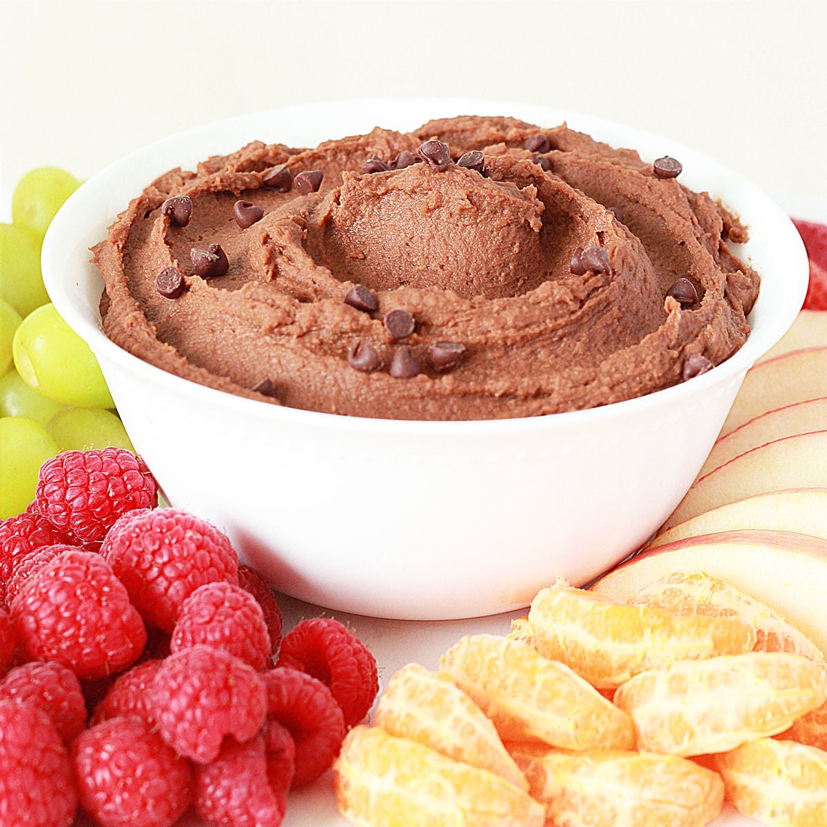bowl of chocolate hummus topped with assorted fruit for dipping