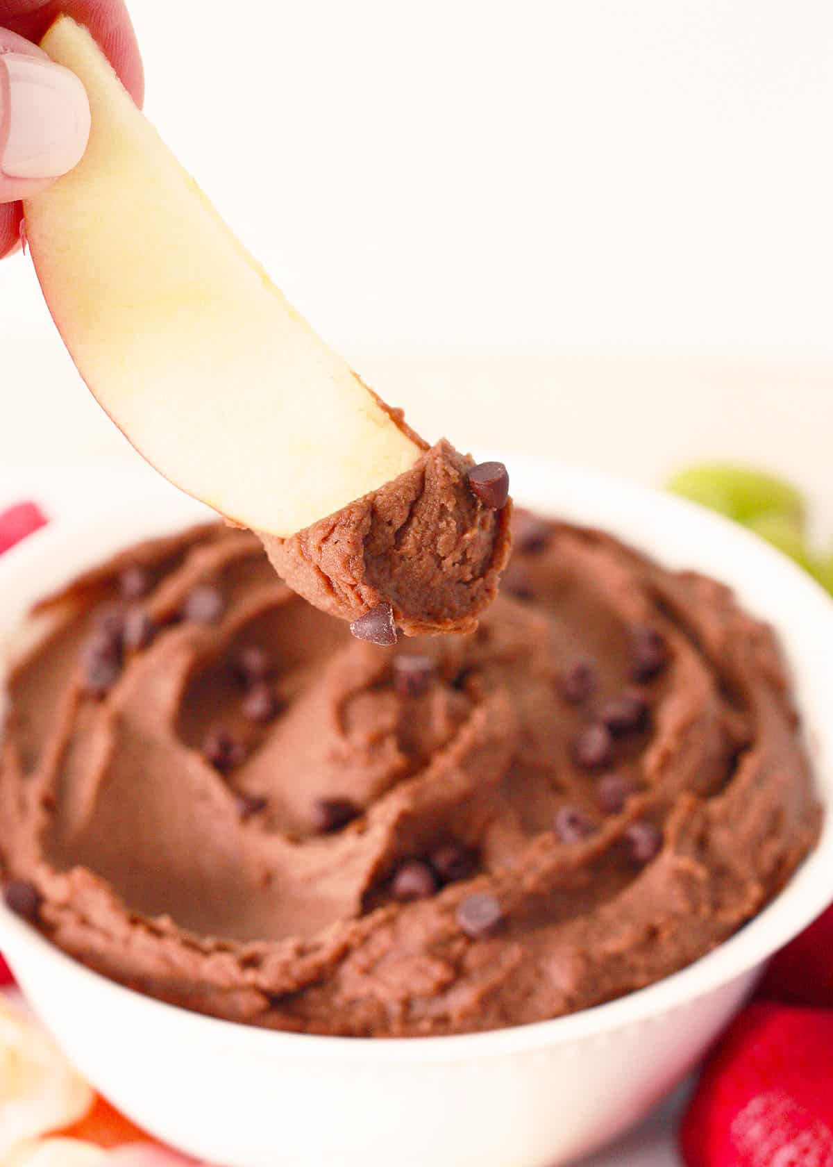 apple slice dipped in chocolate hummus