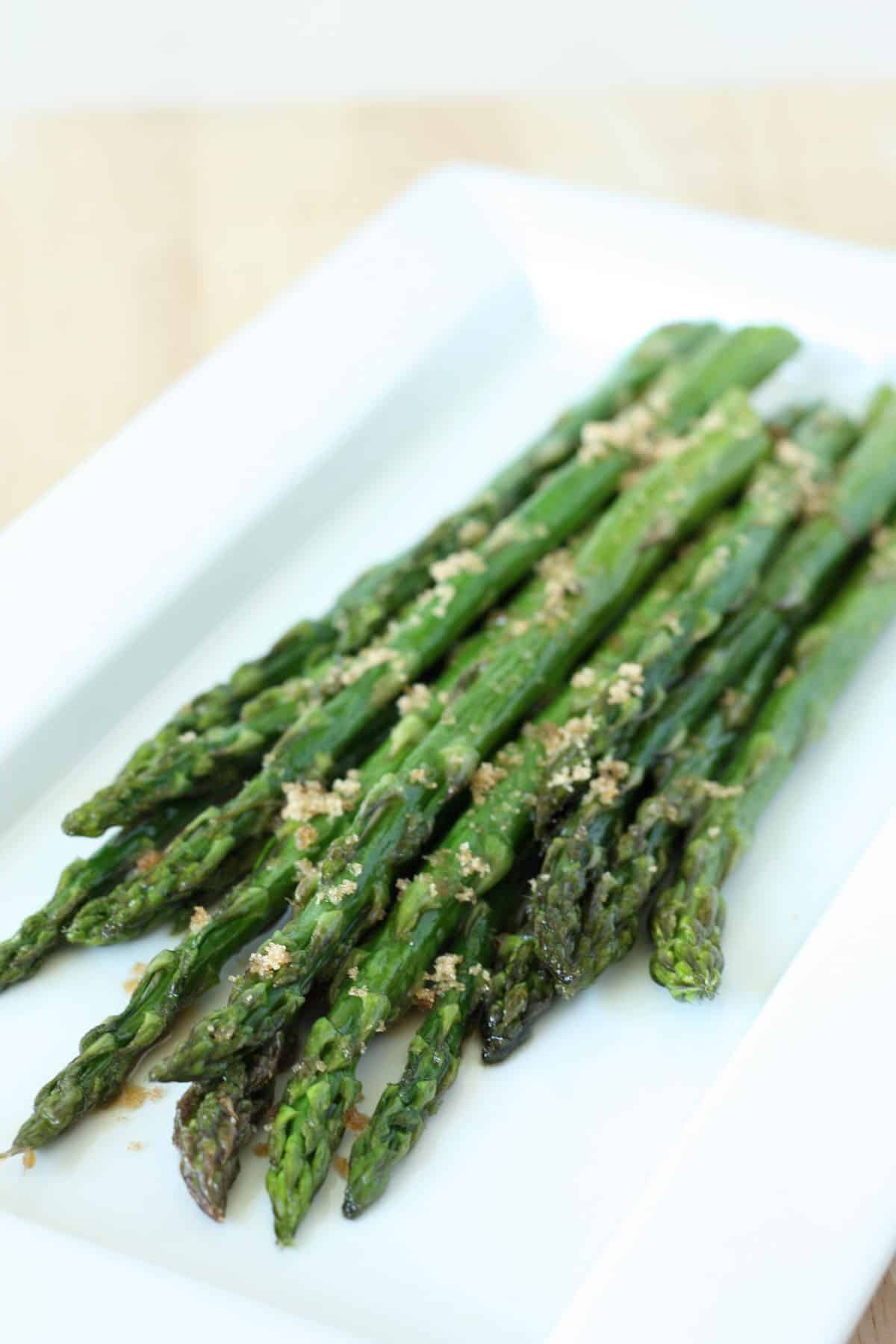 asparagus with brown sugar on a white serving plate