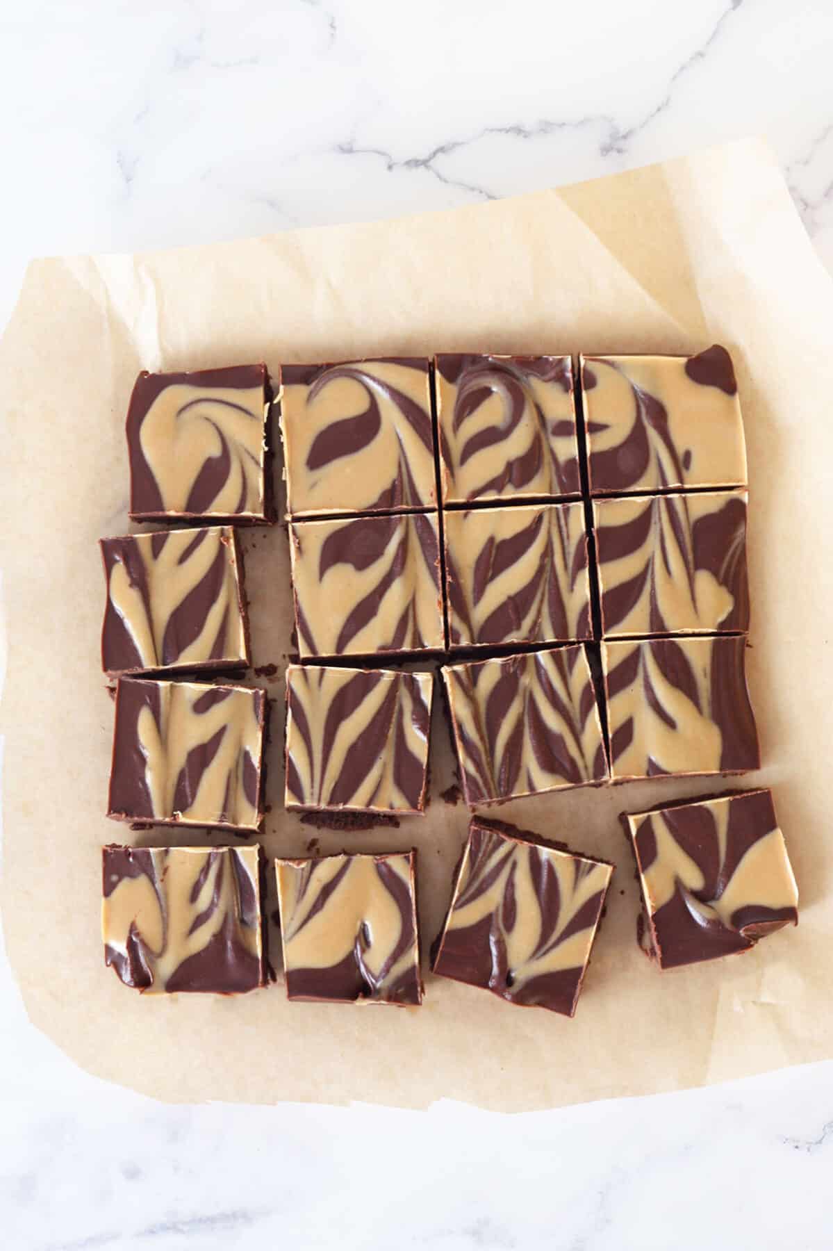 مربع های فاج کره بادام زمینی شکلاتی روی یک ورق کاغذ روغنی
