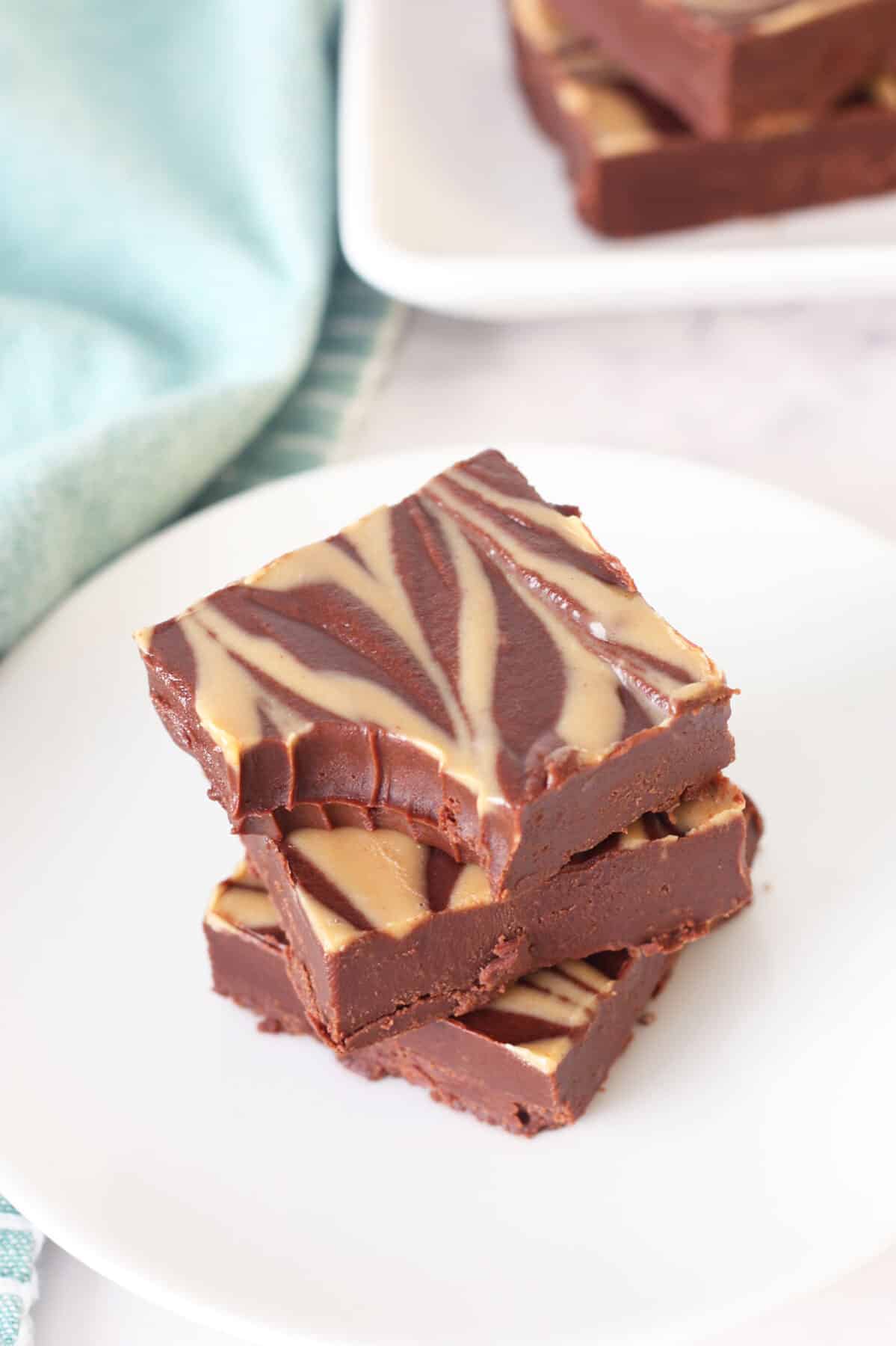 peanut butter swirled chocolate fudge stacked on a small plate