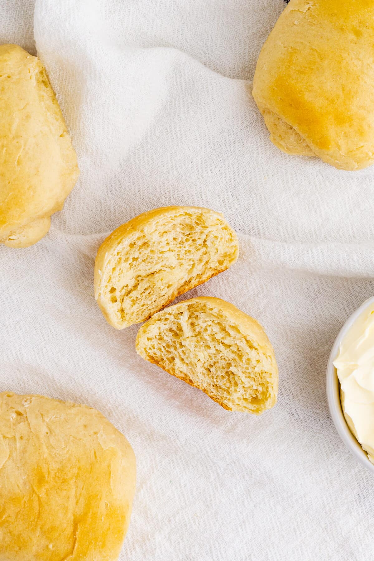 a homemade roll torn in half on a tea towel