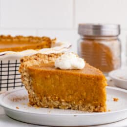 Slice of sweet potato pie topped with whipped cream