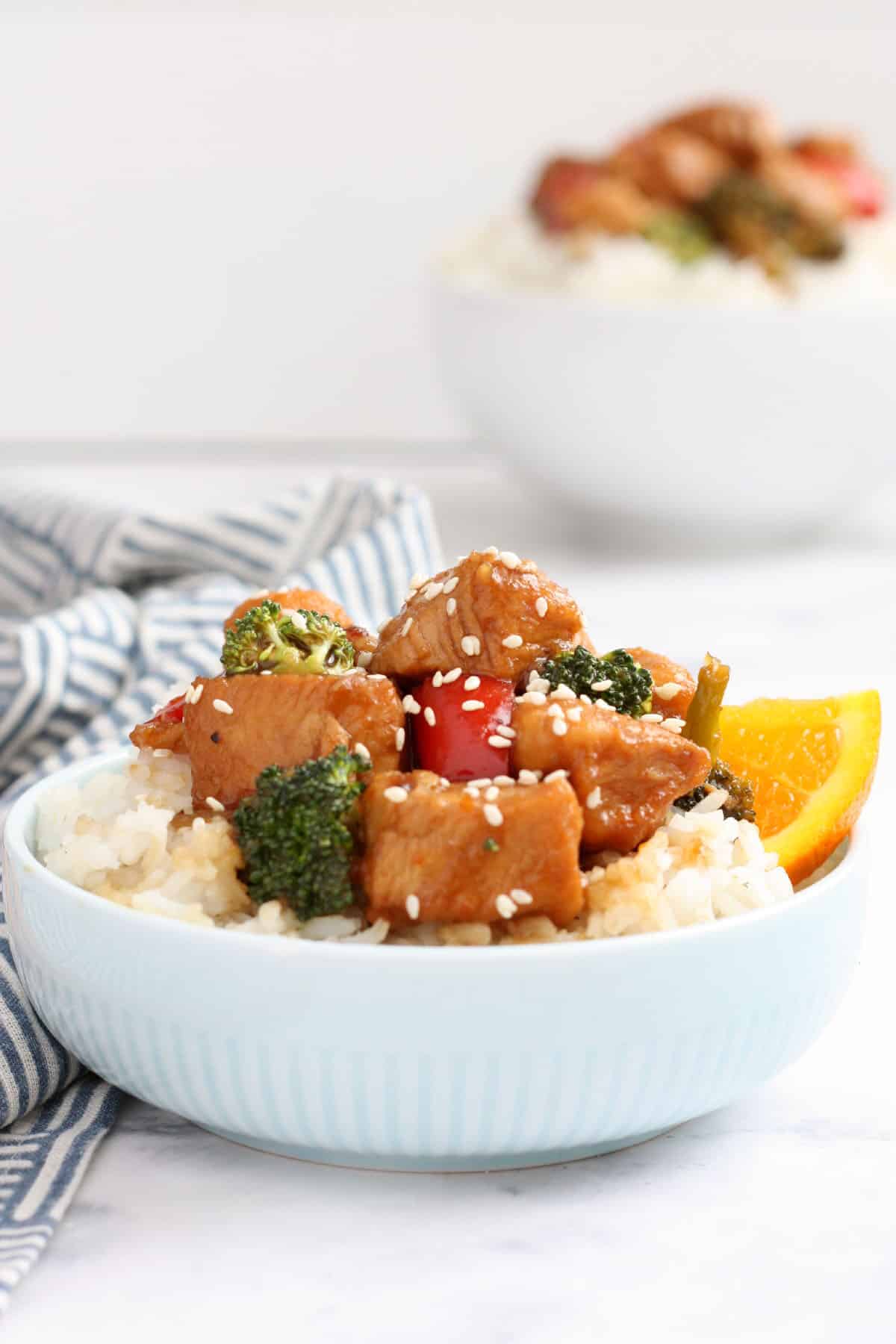 Orange chicken broccoli and peppers served over white rice