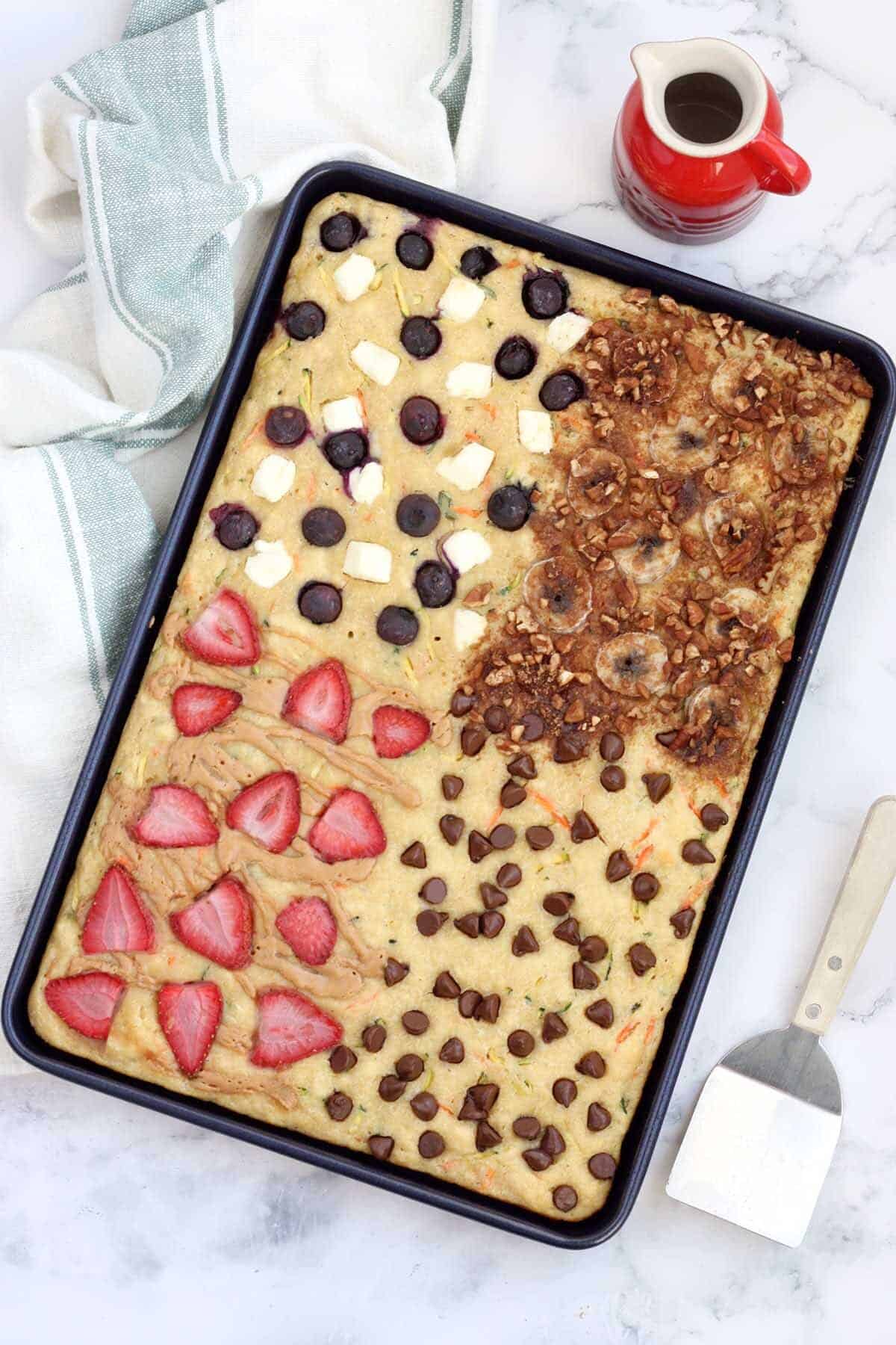 fruit and vegetable sheet pan pancakes on a striped towel