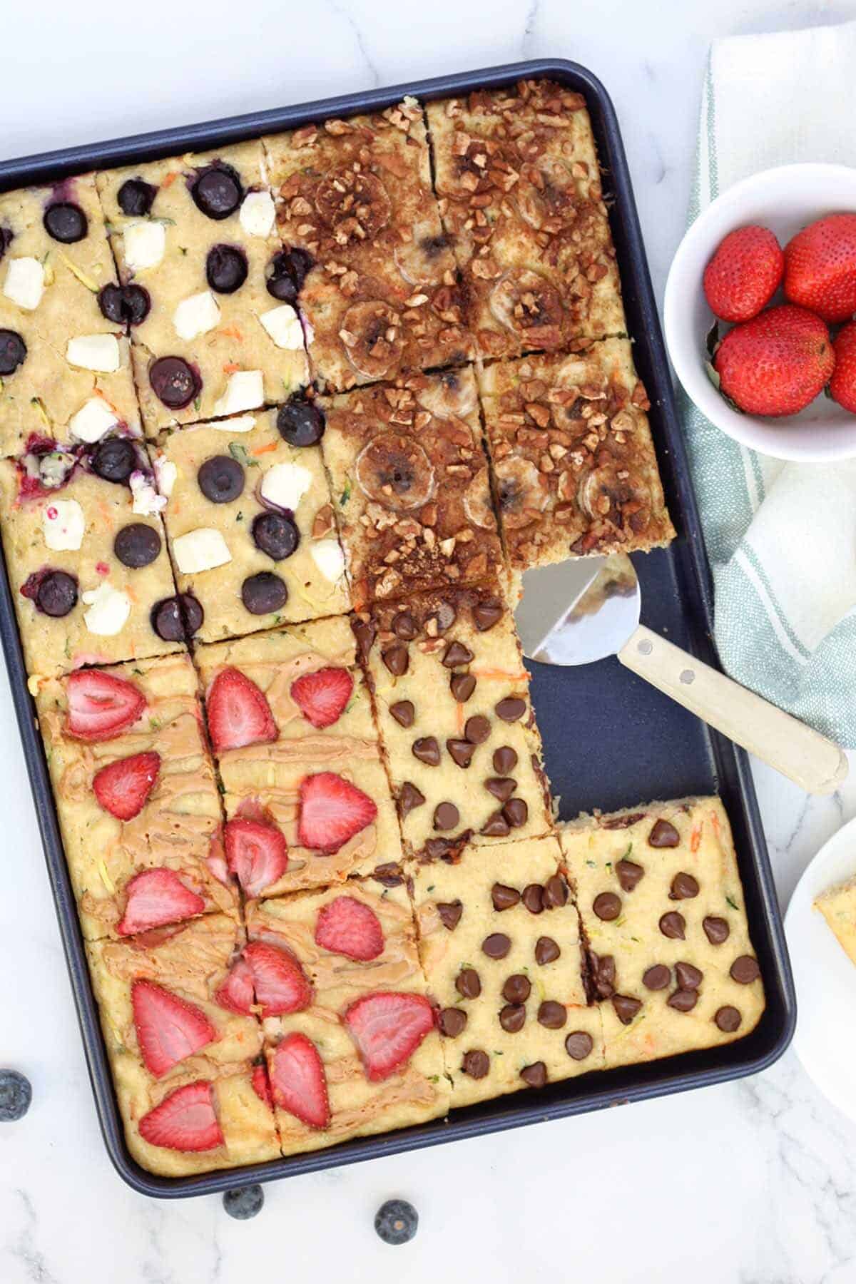 Close up of sheet pan pancakes with a bowl of strawberries