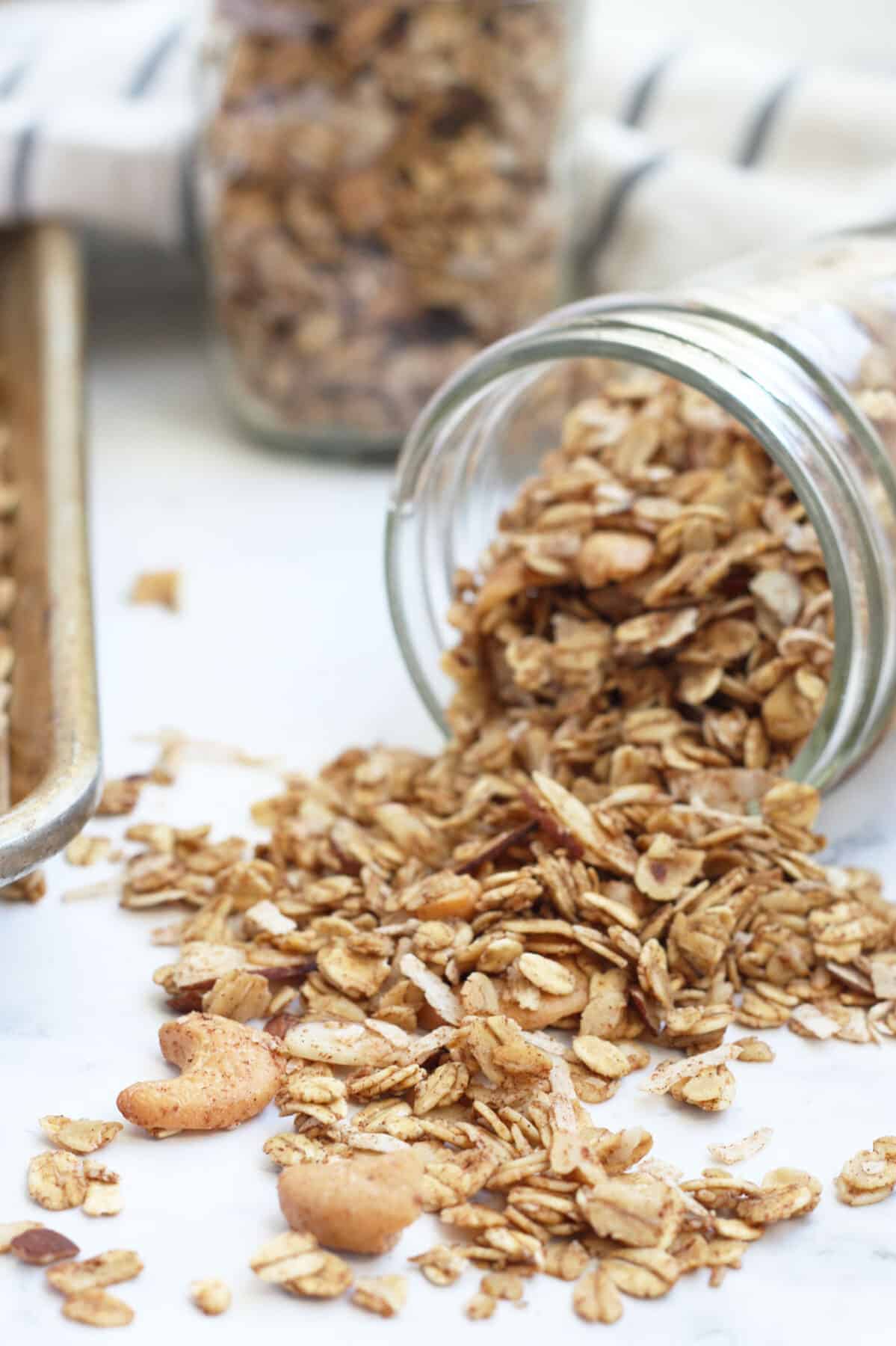 sugar free granola in a small mason jar tipped over with the granola spilling out