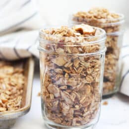 sugar free granola in a mason jar with a baking sheet and another mason jar with granola in the background