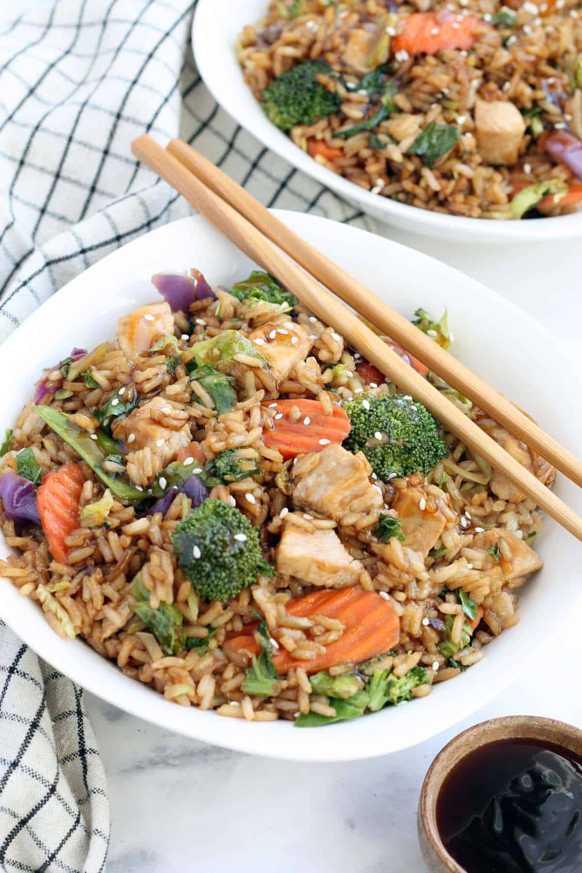 Teriyaki chicken with rice and wooden chopsticks in a white bowl