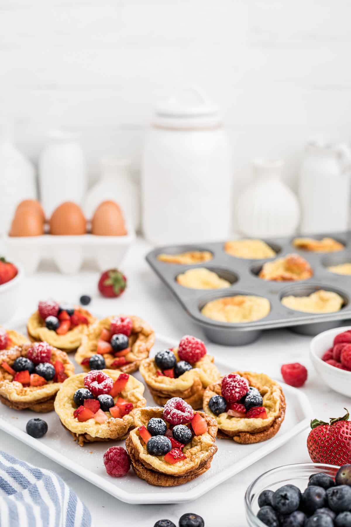 homemade popovers on a white tray with berries