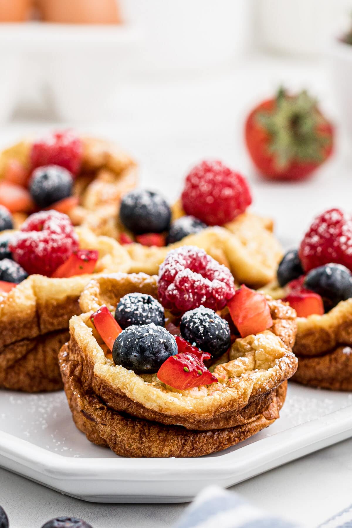 Close up of popovers filled with berries and powdered sugar