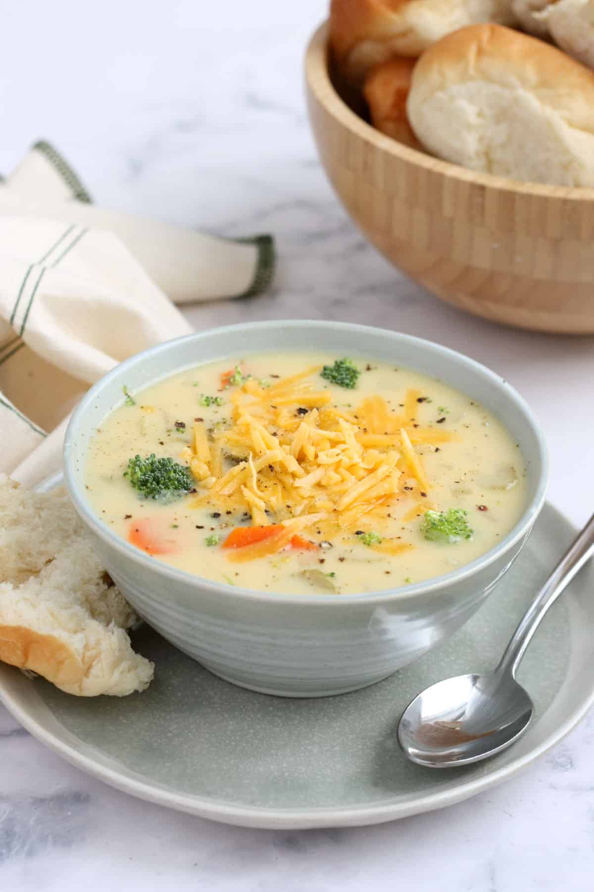 a bowl of crockpot cheese and vegetable soup with fresh bread