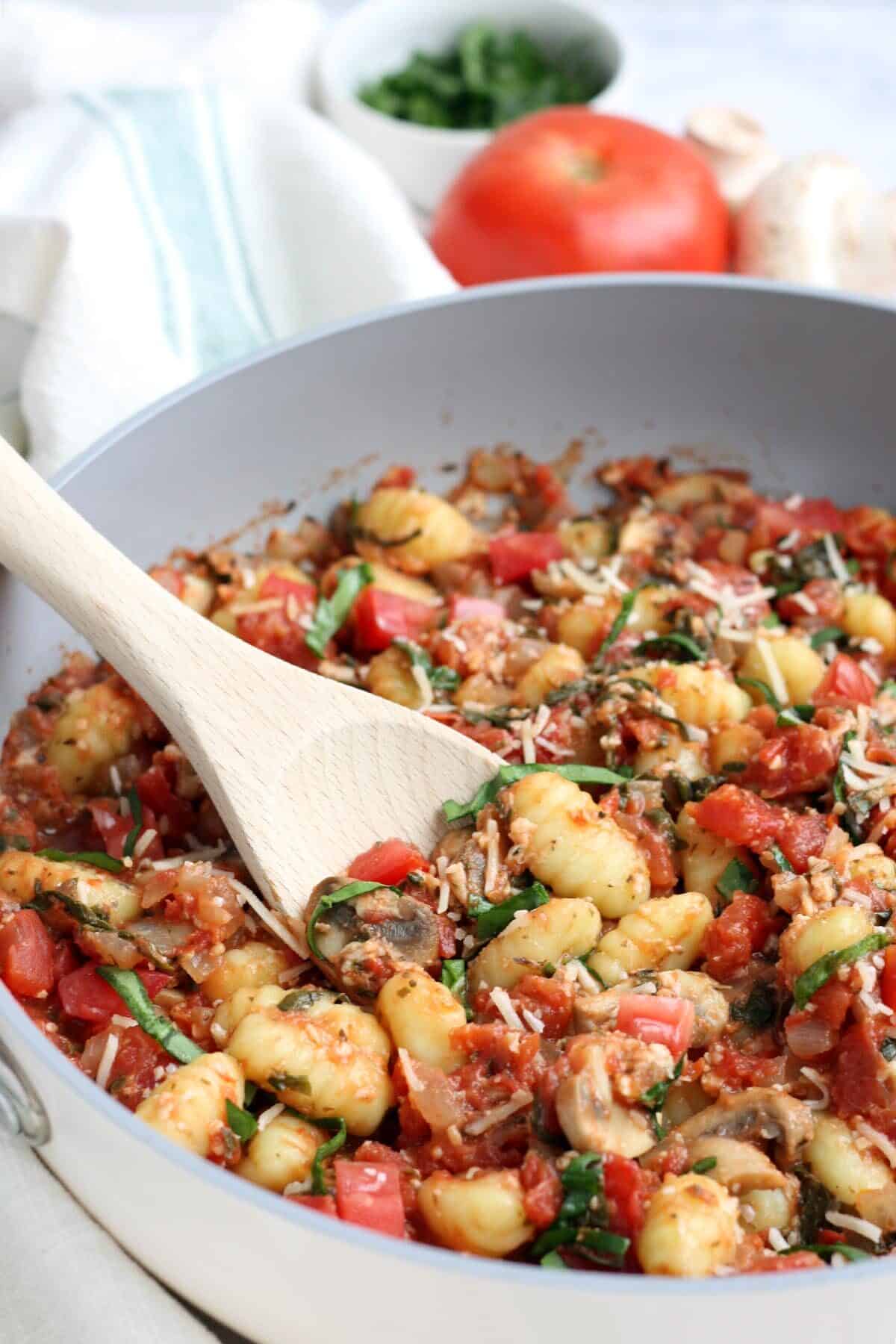 Simple gnocchi with mushrooms and tomatoes in a pan