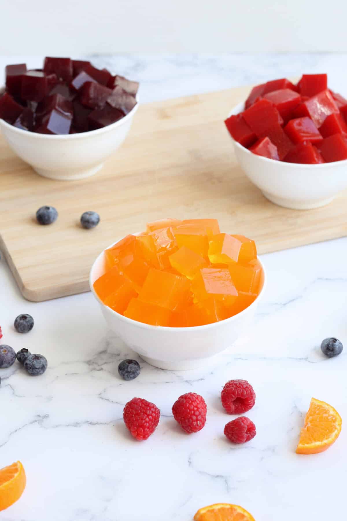 Bowls of homemade jello in a variety of flavors with fresh fruit