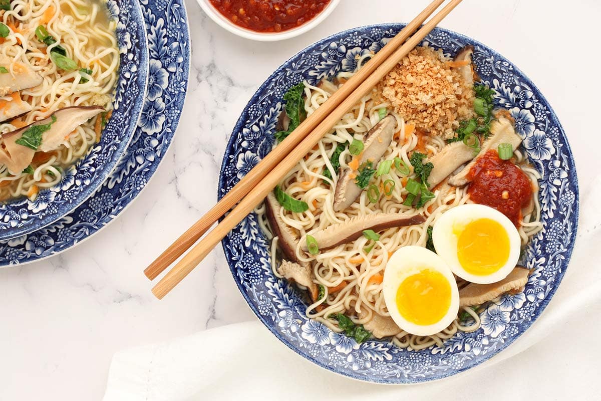 two bowls of homemade ramen served with soft eggs and chili sauce