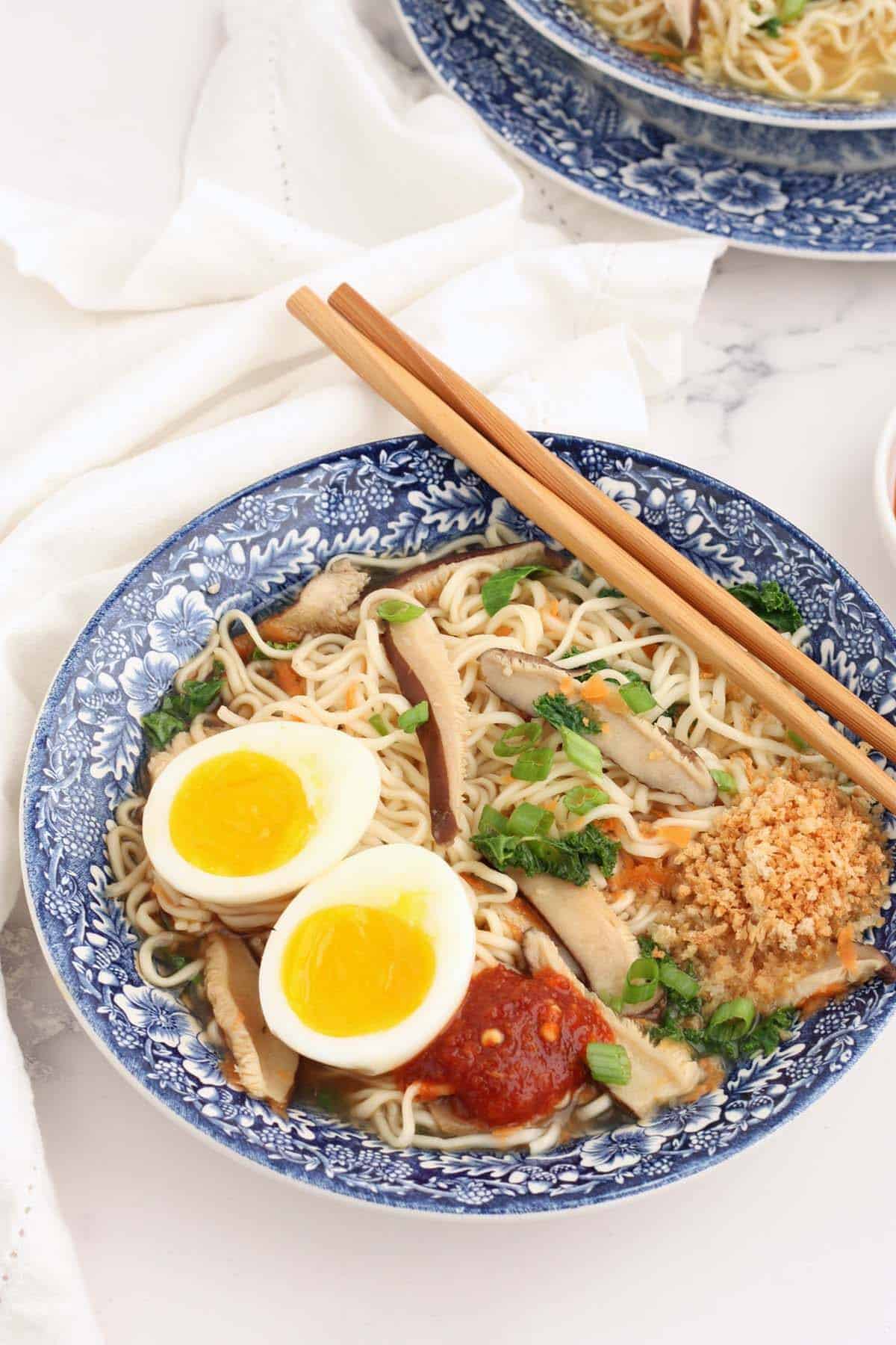 homemade ramen noodles in a blue bowl with chopsticks