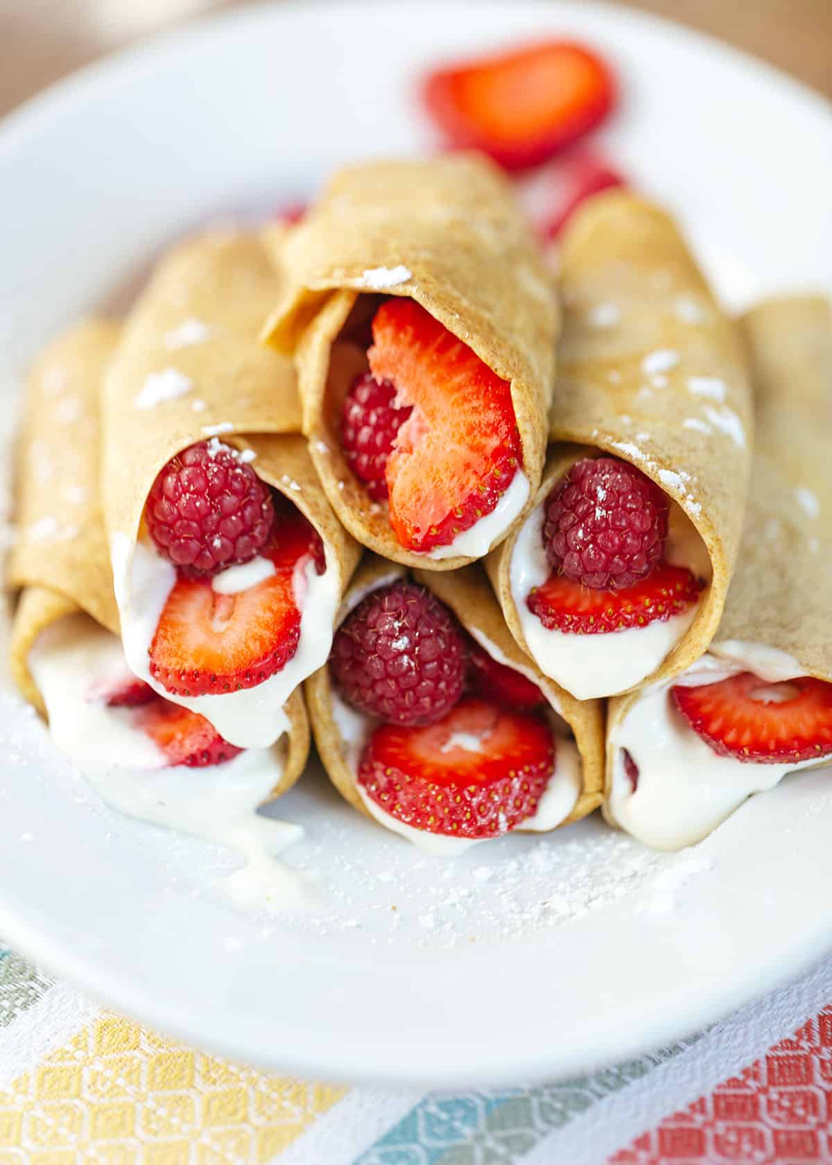 Close-up of strawberry crepes stacked on a white plate