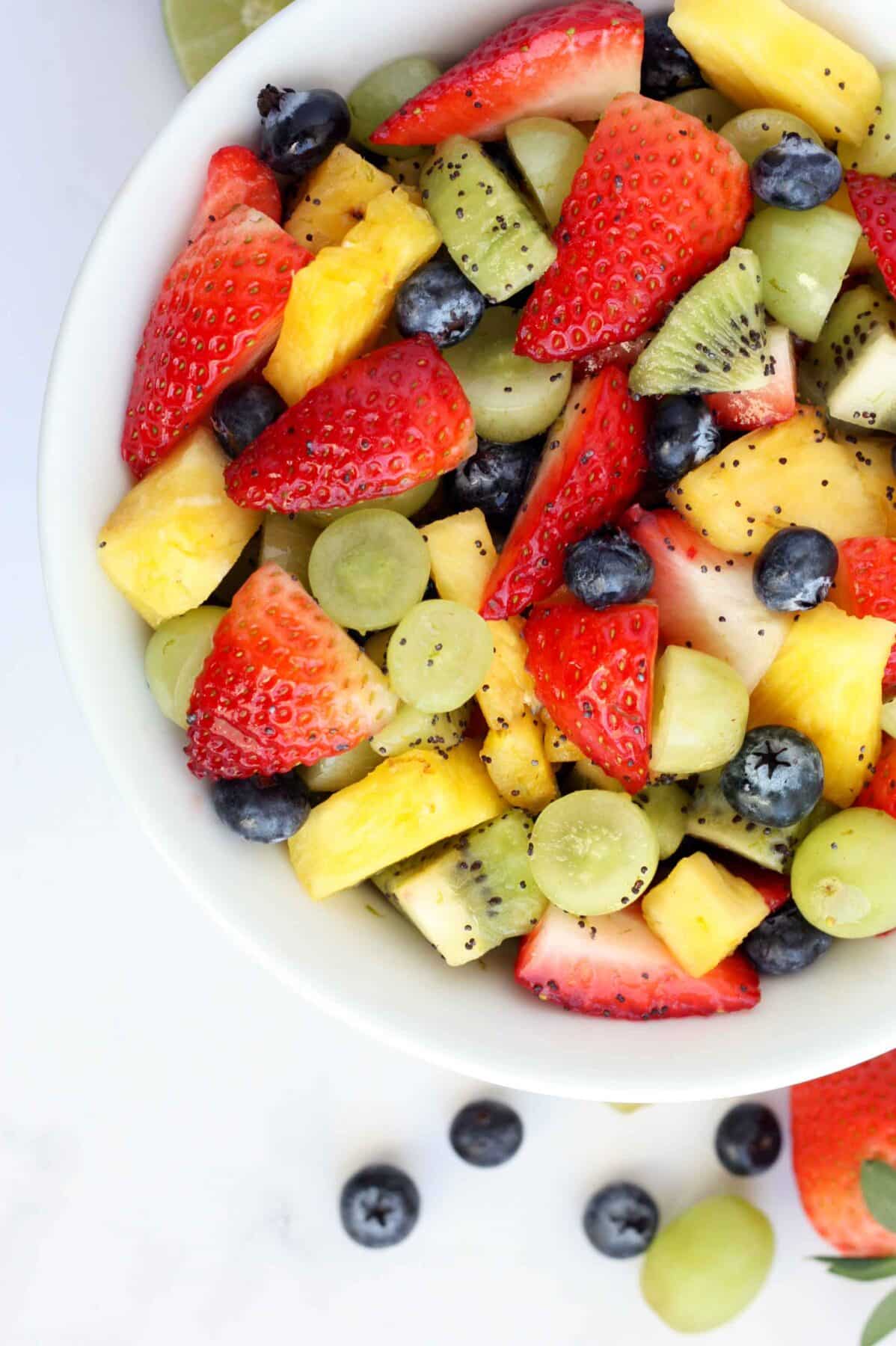 a close up shot of honey lime fruit salad