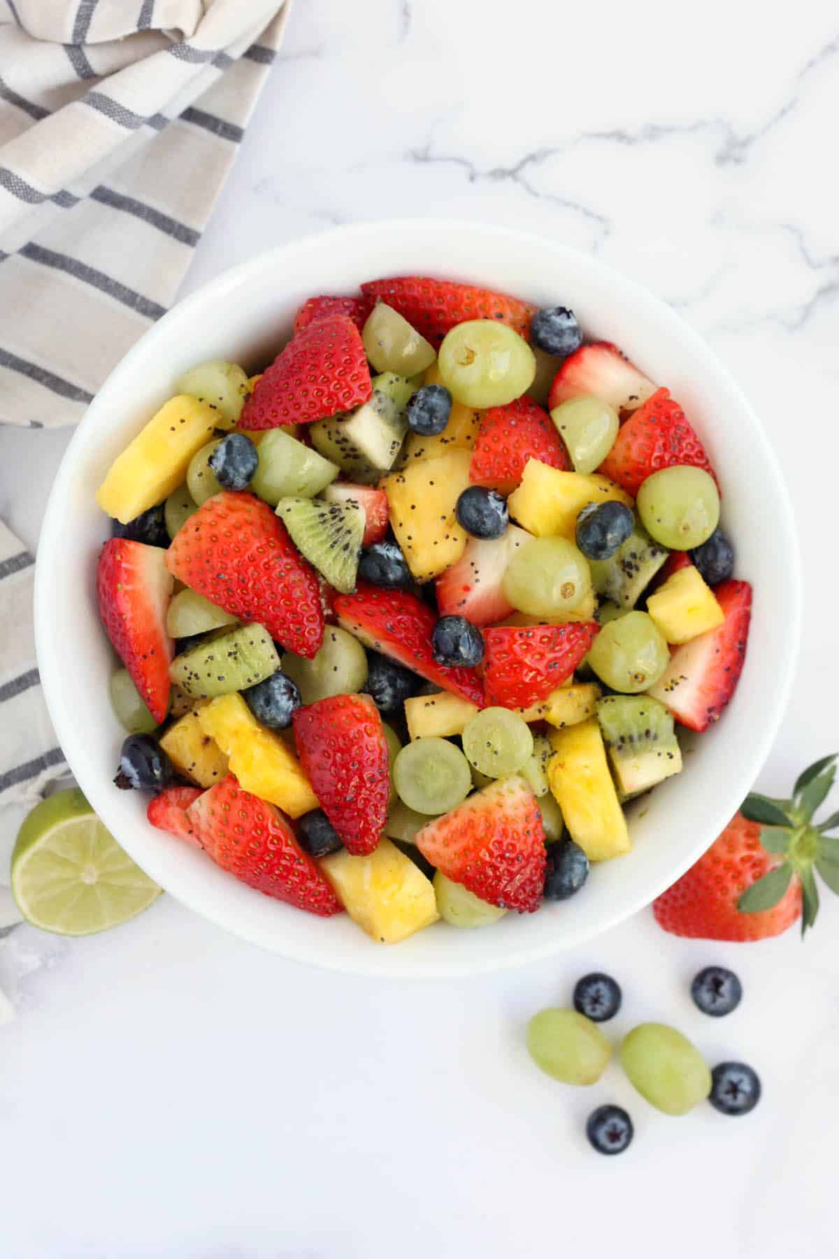 honey lime fruit salad in a white bowl