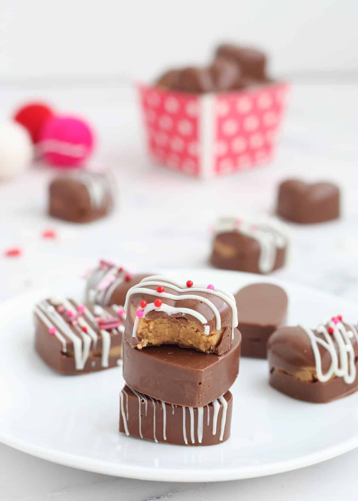 heart shaped peanut butter cups with a white drizzle and sprinkles