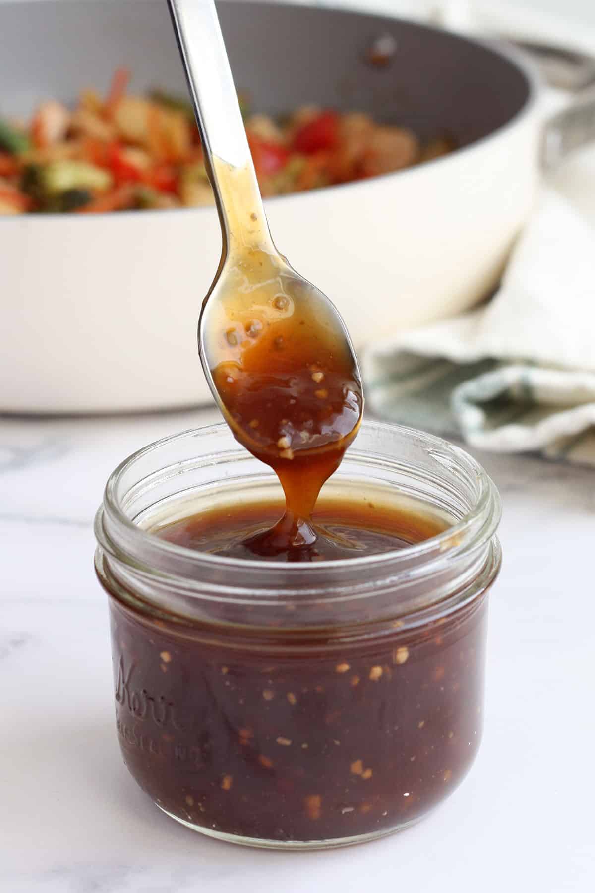 homemade wok sauce in a jar with a spoon