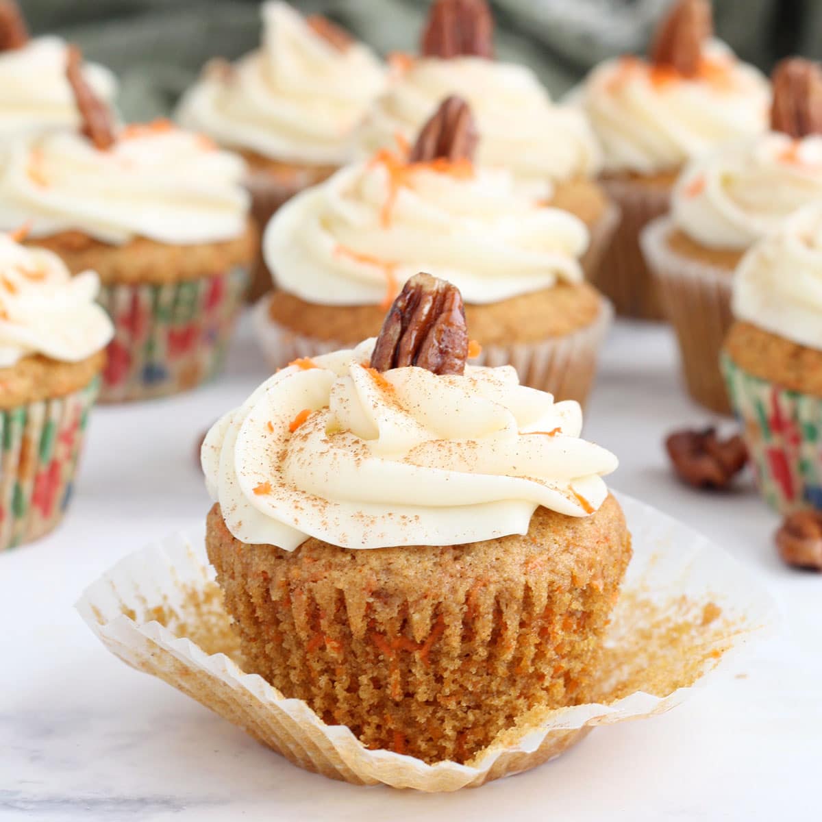 a carrot cake topped with a cream cheese frosting swirl