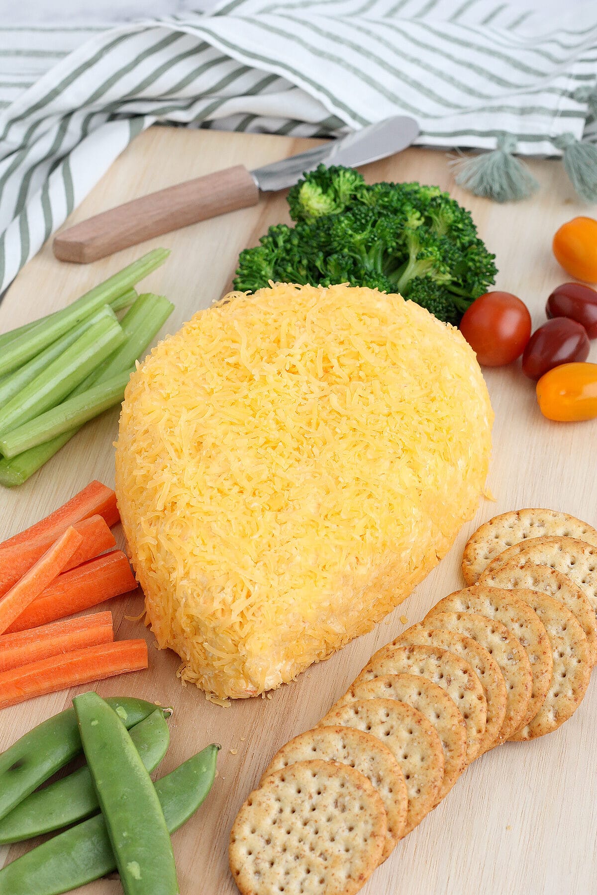 a cheeseball shaped like a carrot with crackers and vegetables