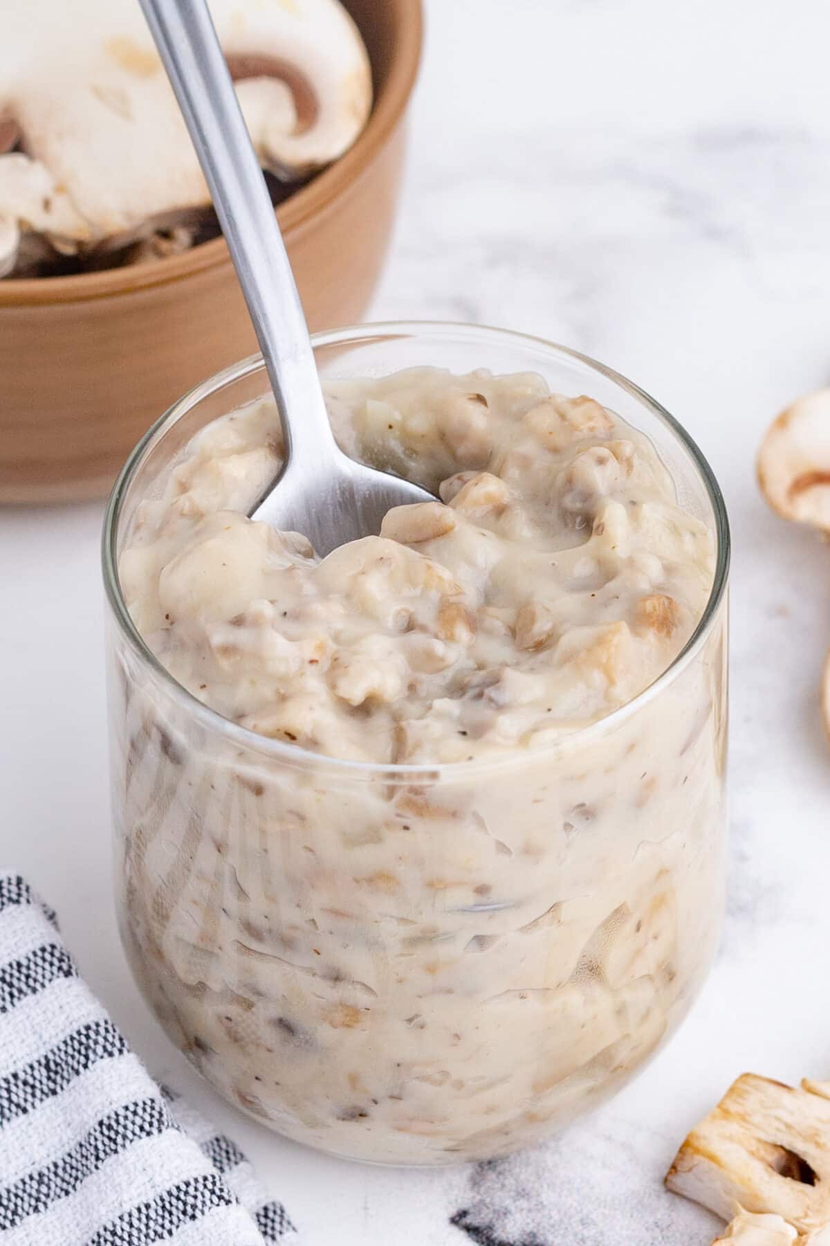 a glassful of homemade cream of mushroom soup with a spoon