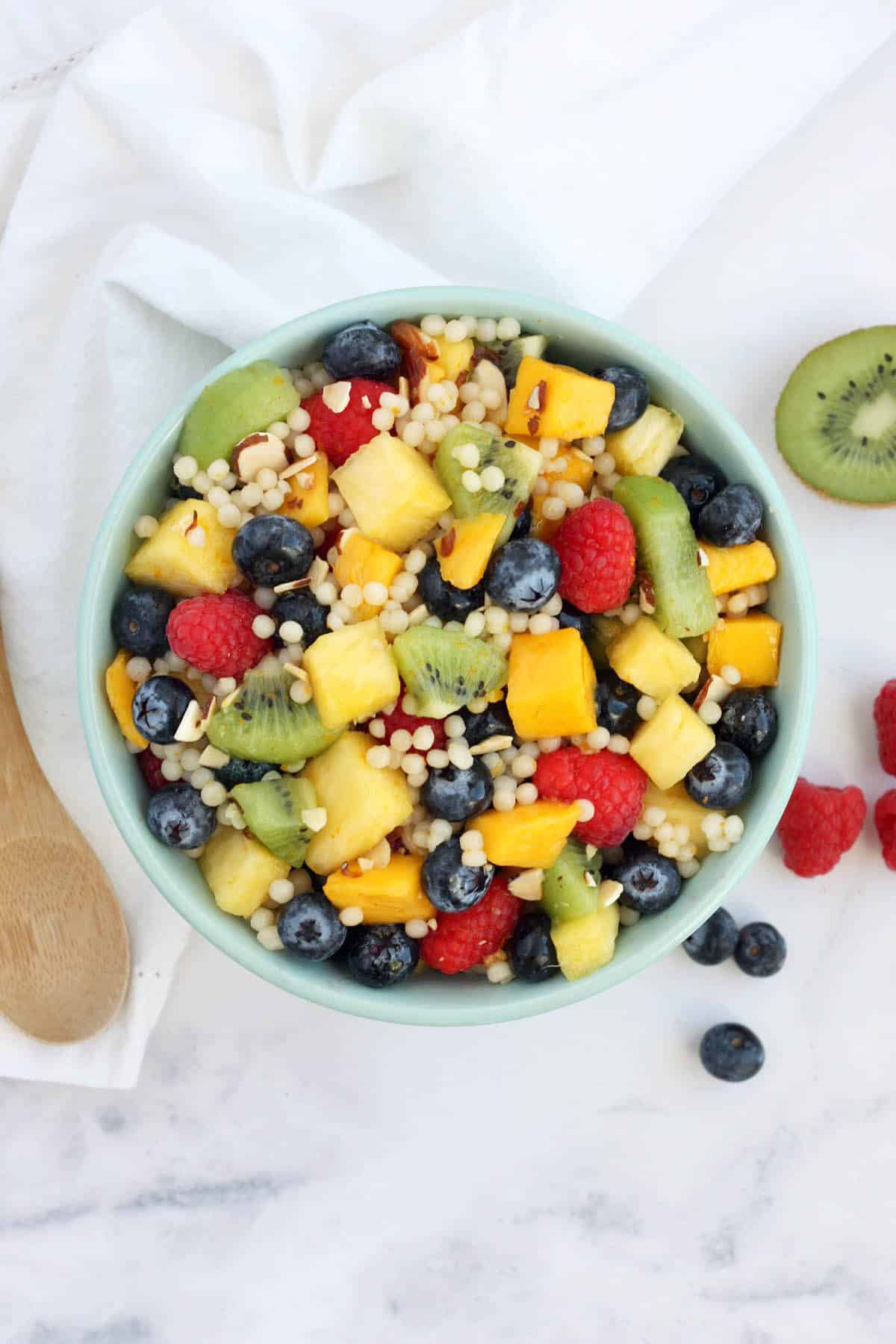 an overhead shot of a fruit salad recipe in a blue bowl