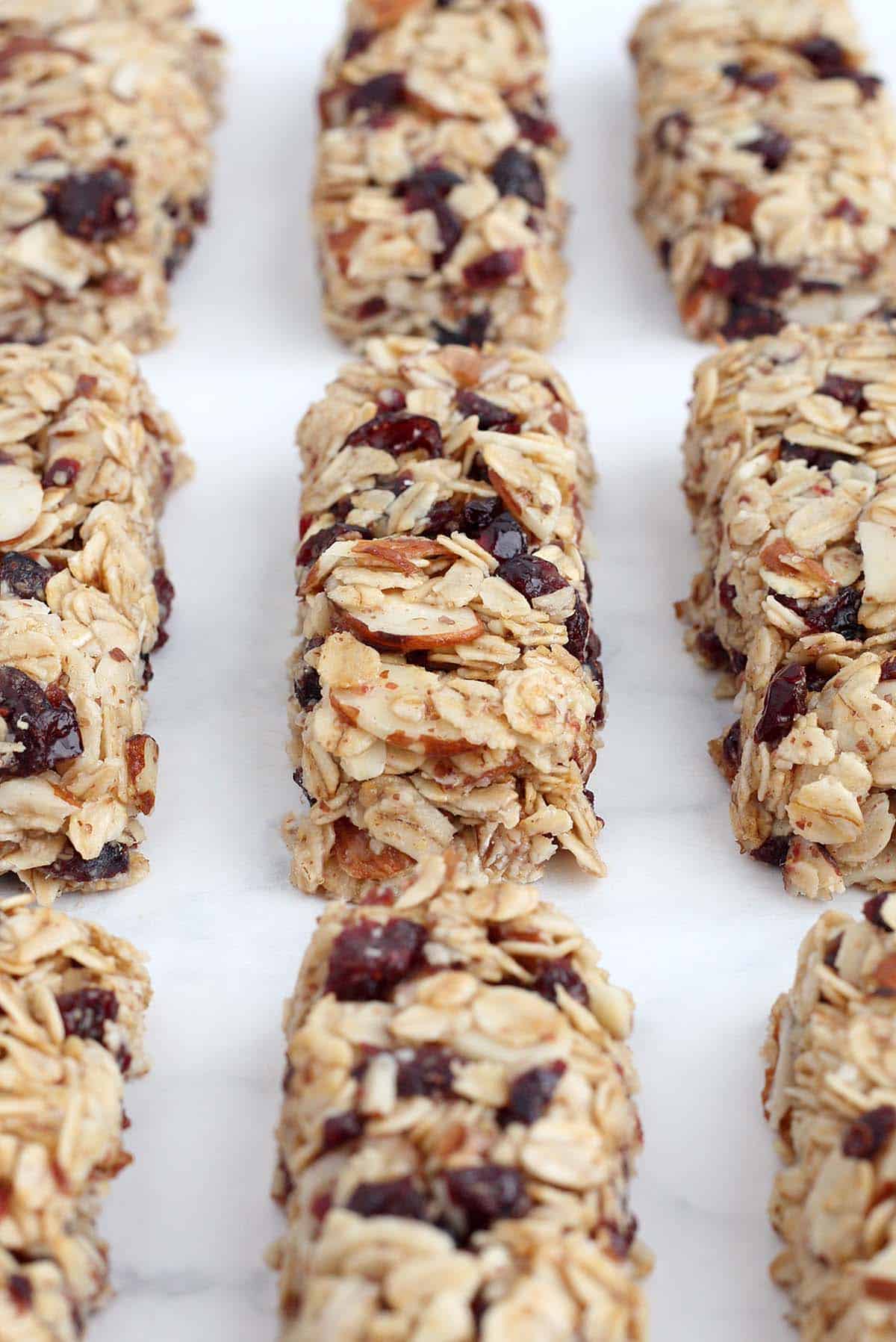 a close up shot of oatmeal bars with almonds and dried cranberries