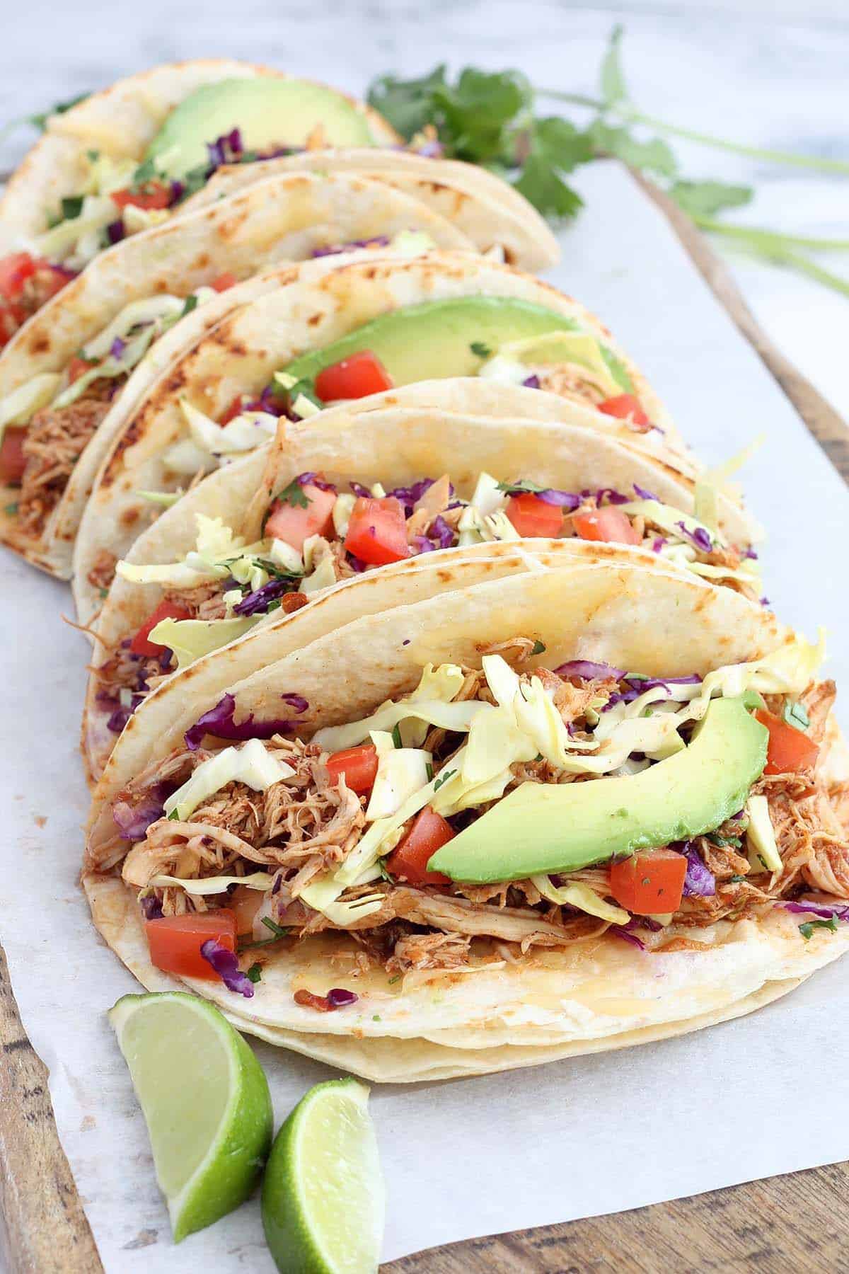 chicken tacos with avocado, cabbage, tomatoes, and fresh lime