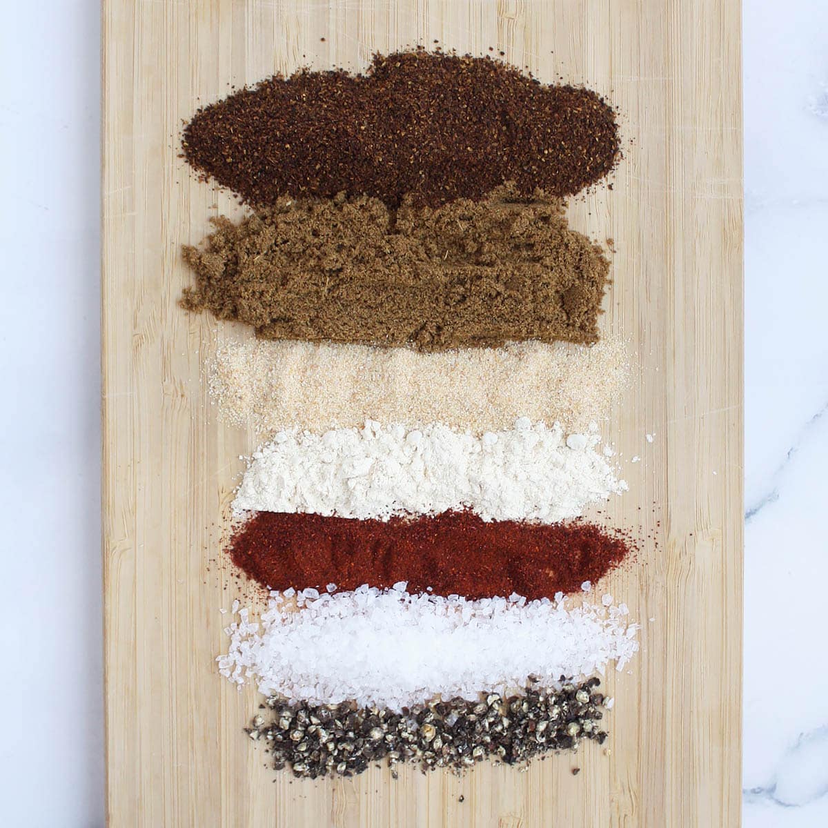 mexican spices for taco seasoning spread out on a wooden board