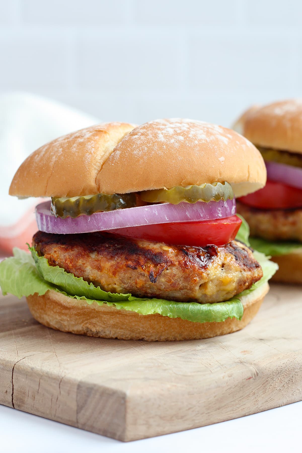 A juicy turkey burger on a bun with lettuce, tomato, onion and pickles.