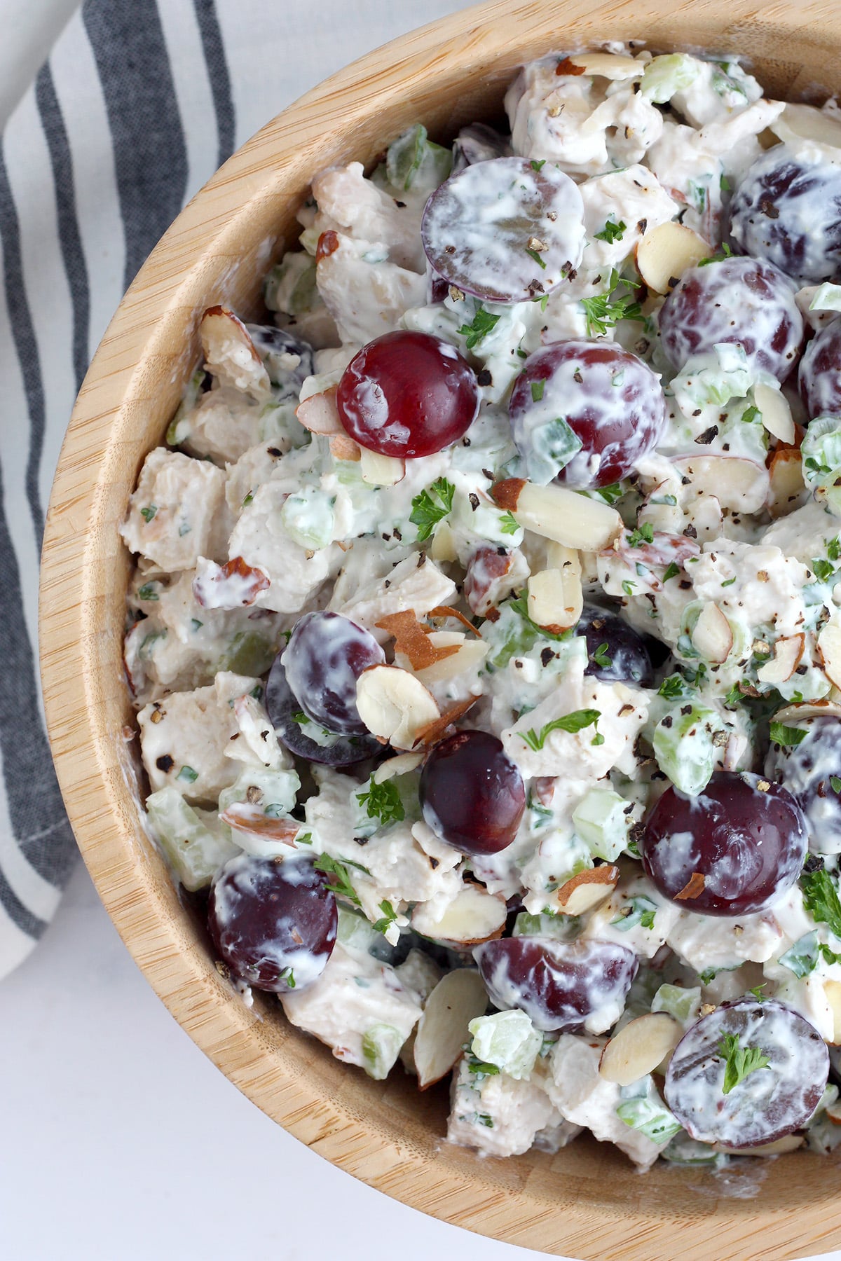 Chicken Salad with grapes and sliced almonds in a wooden bowl.