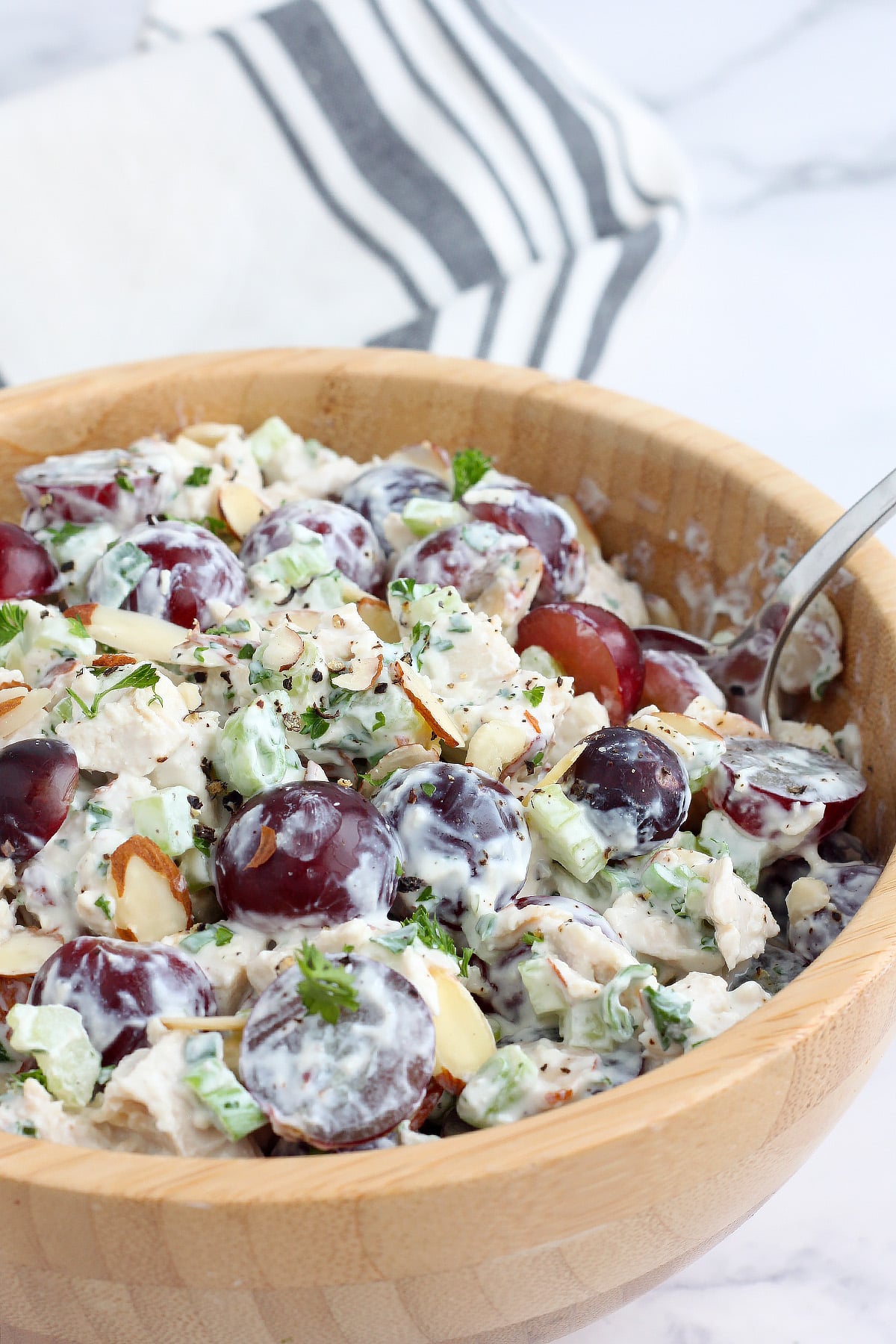 A bowl of homemade chicken salad with celery, grapes, almonds, and greek yogurt.