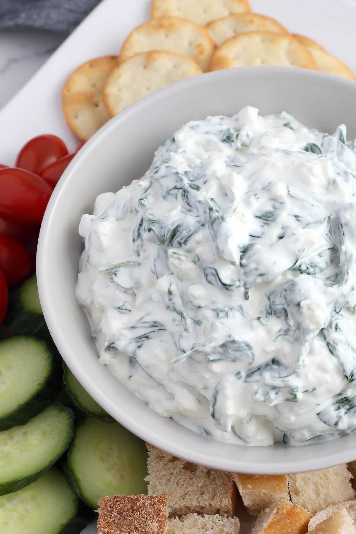 Creamy, healthy spinach dip in a bowl with assorted dippers.