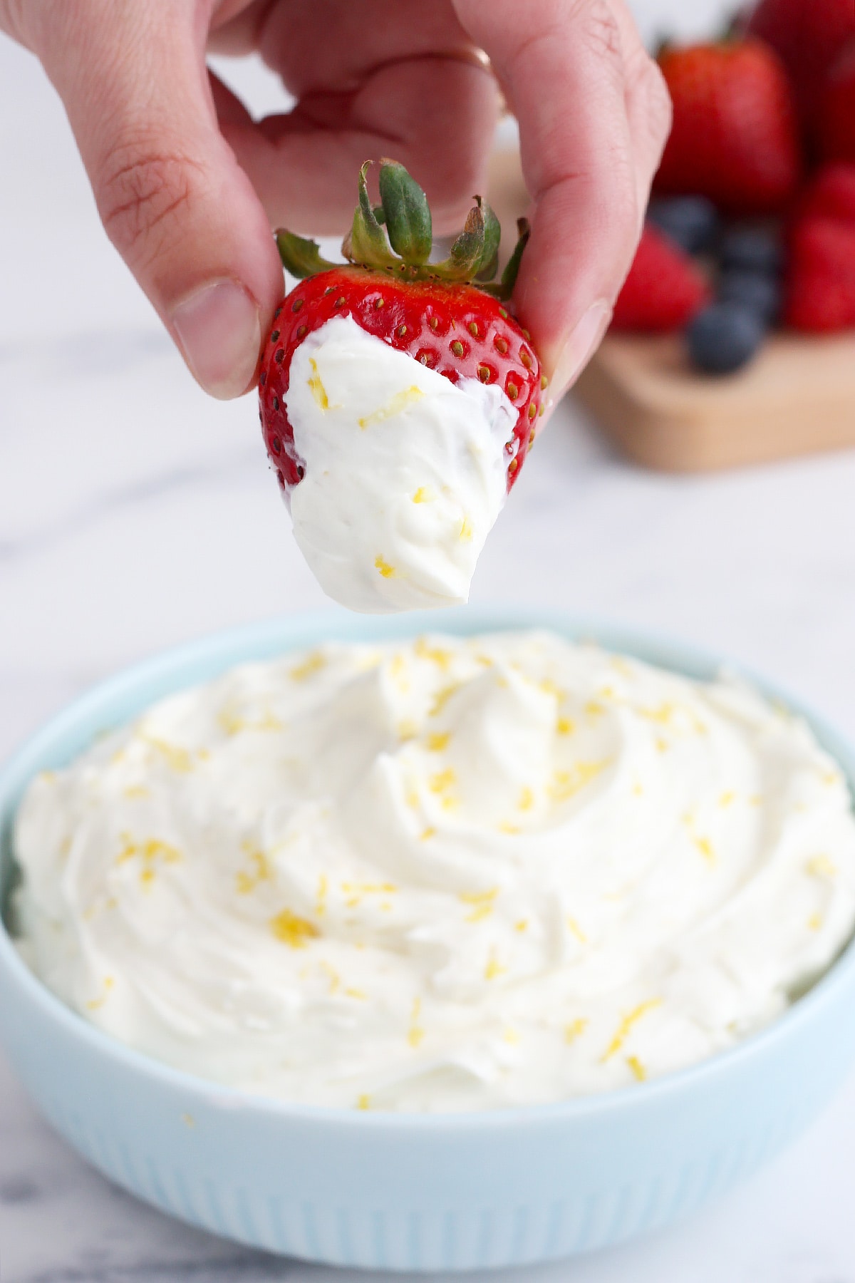 A strawberry dipped in creamy fruit dip.