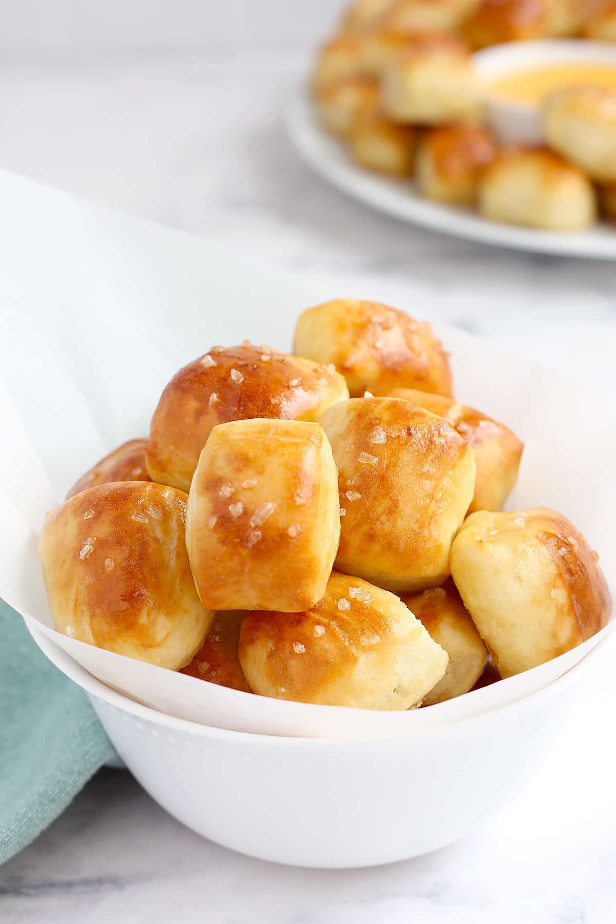 Soft, buttery pretzel bites in a small white serving bowl with parchment.