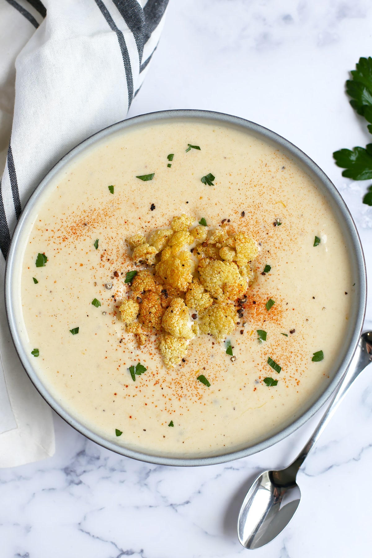 creamy cauliflower soup in a bowl with roasted cauliflower on top as a garnish