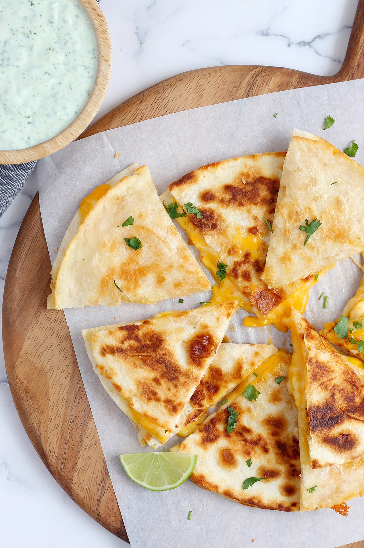 Perfectly browned quesadilla cut into triangles with melty cheese and sprinkled with chopped cilantro.