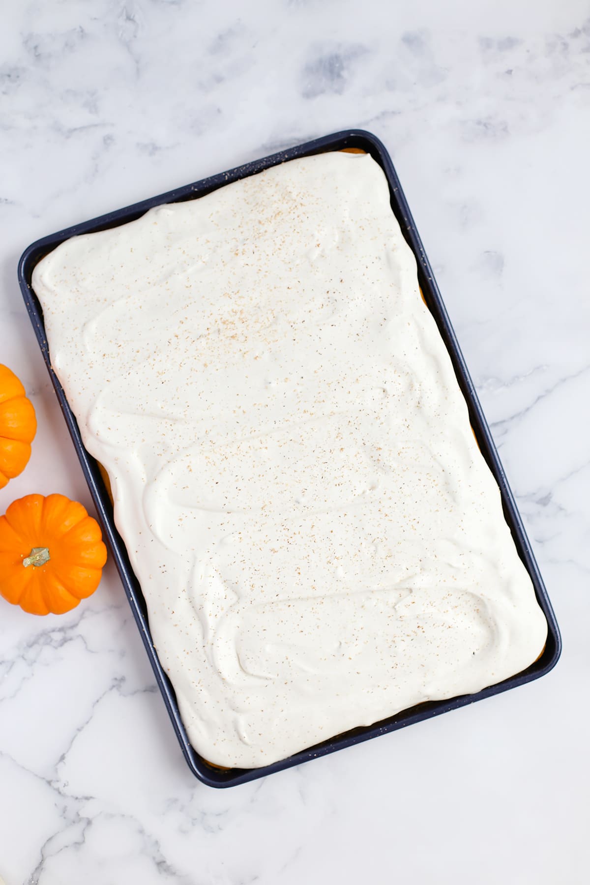 Pumpkin cake with a fluffy topping in a blue baking pan.