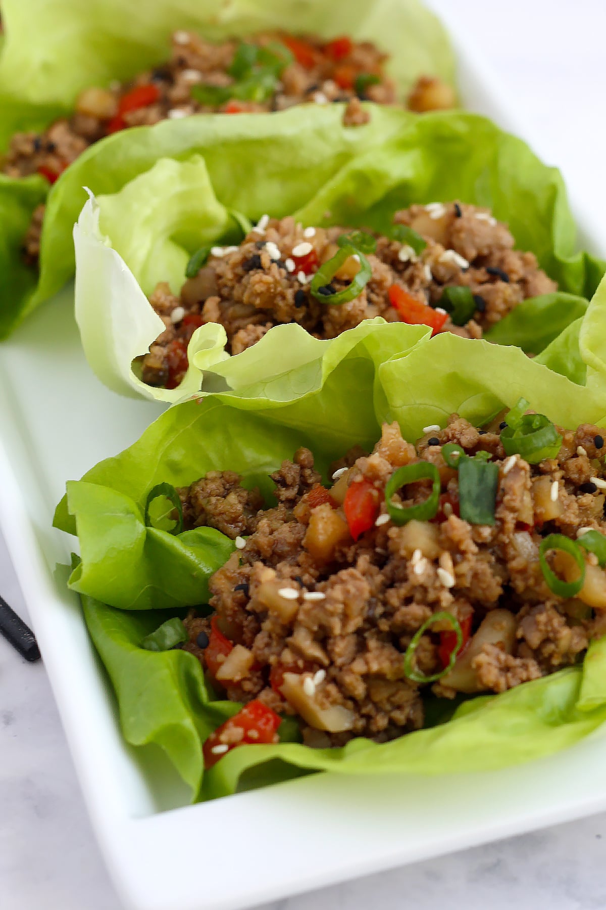 asian lettuce wraps with mushrooms, bell peppers and water chestnuts in bib lettuce