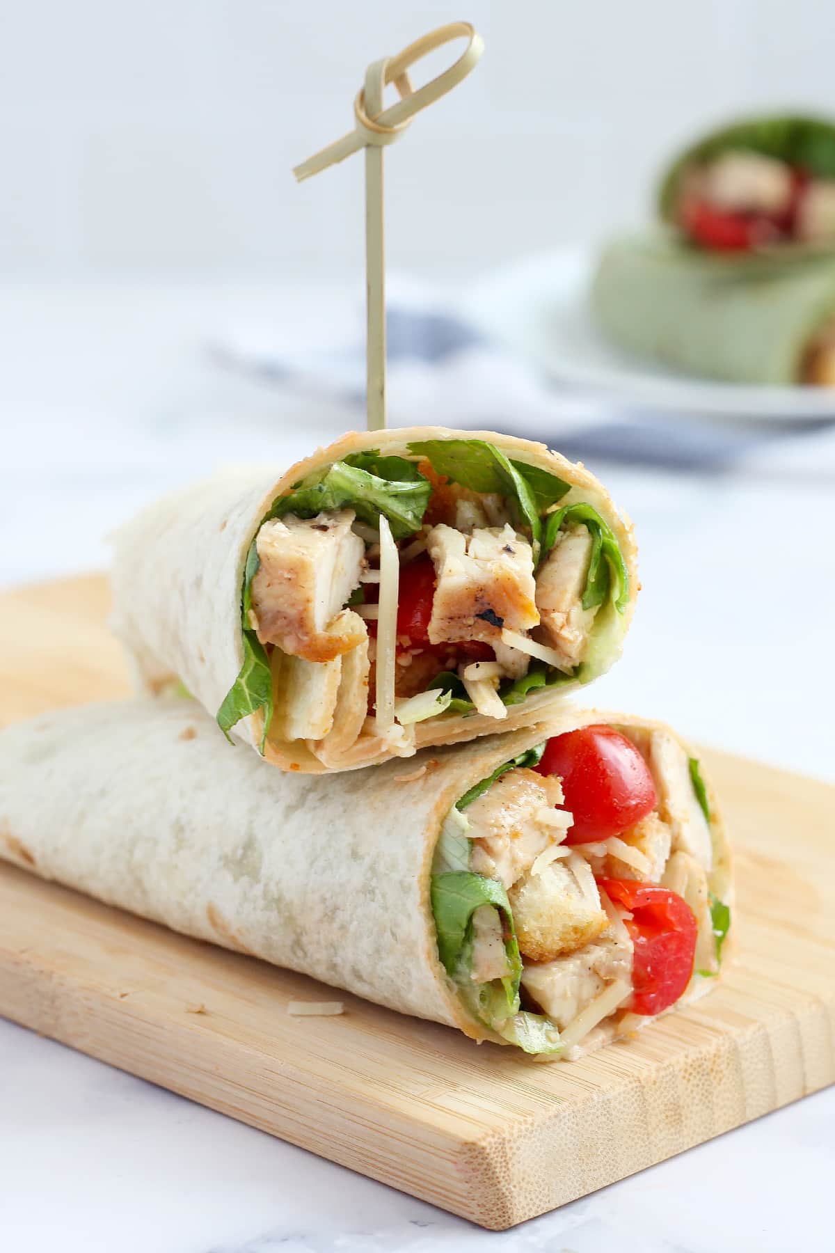 chicken caesar wraps in a flour tortilla with fresh tomatoes, parmesan and grilled chicken