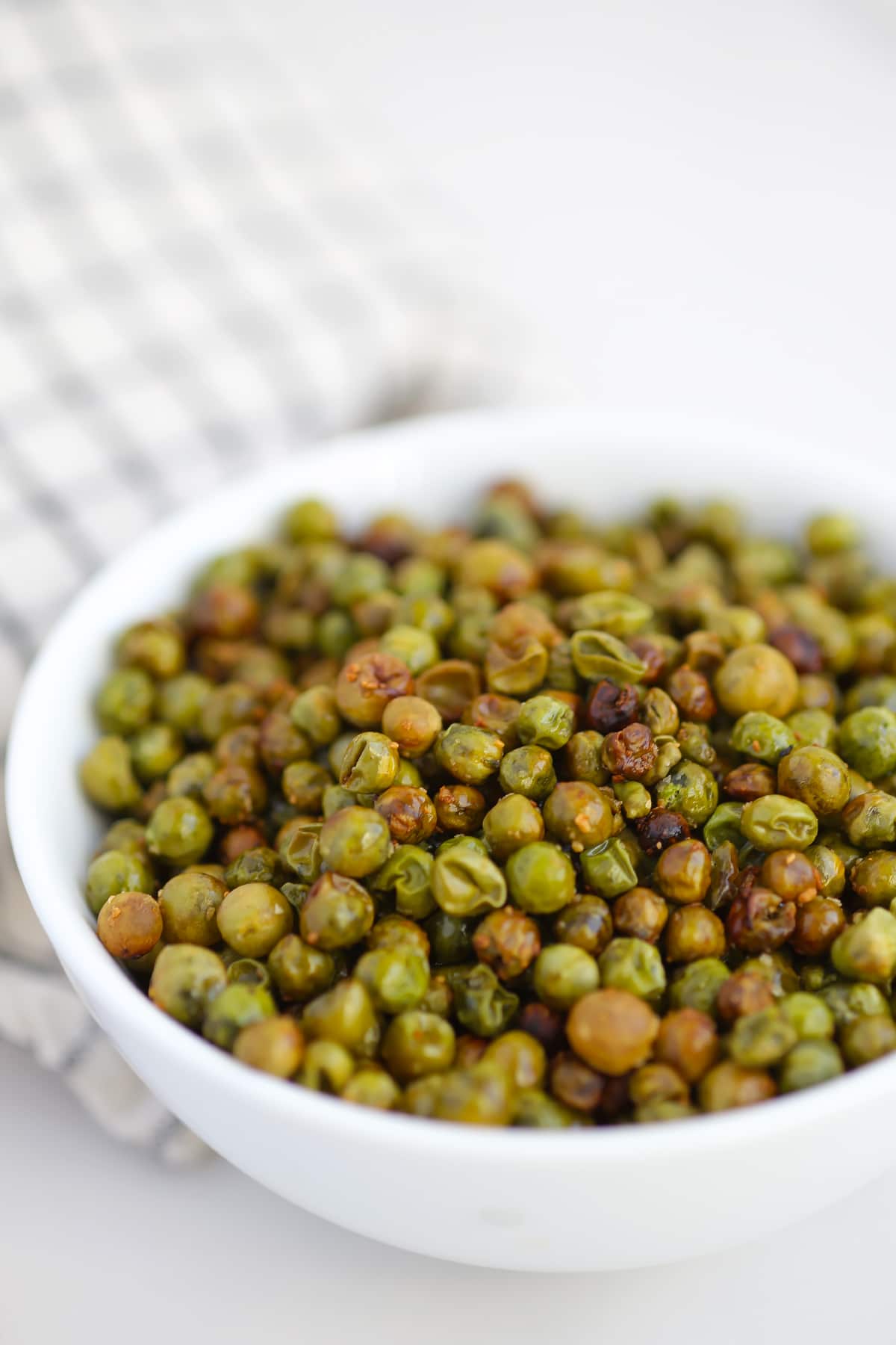 a bowl of roasted crunchy peas with garlic salt in a serving bowl
